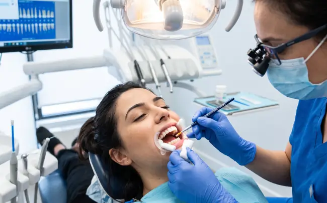 Dentist examining a patient for tooth sensitivity during a professional dental check-up.